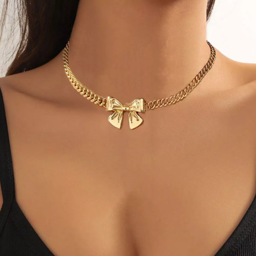 Model wearing an 18K gold-plated bowknot pendant necklace with a Cuban link chain.