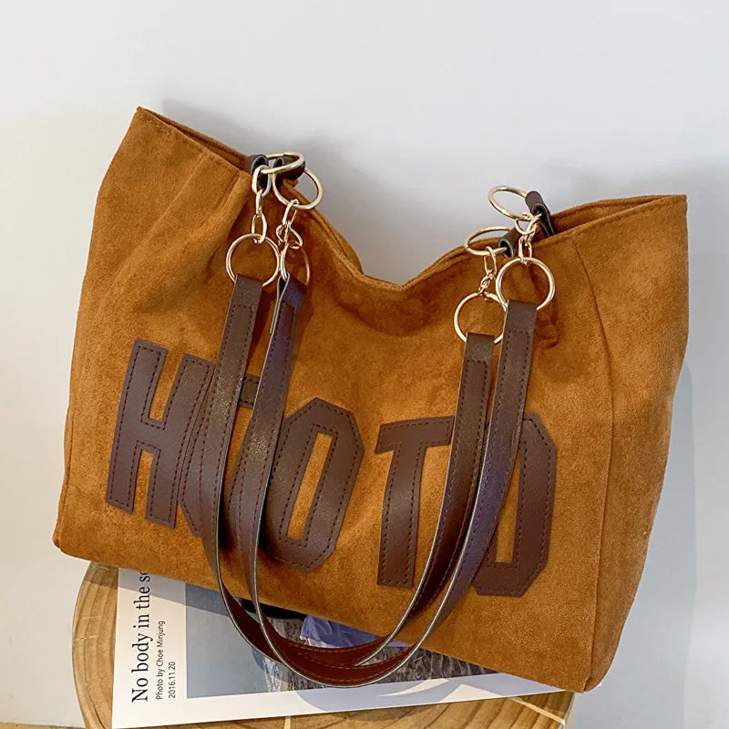 Black canvas campus tote bag - front view showing letter-print design