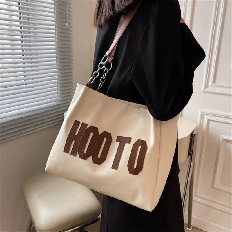 Black canvas campus tote bag - lifestyle shot carried on campus