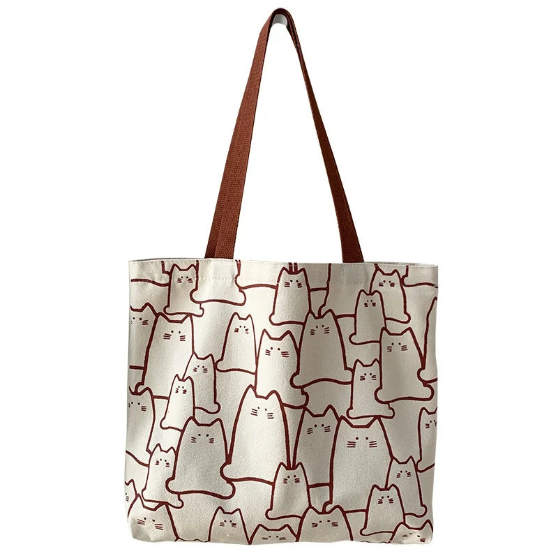 Beige cat-print canvas tote bag - close-up of shoulder strap and handle