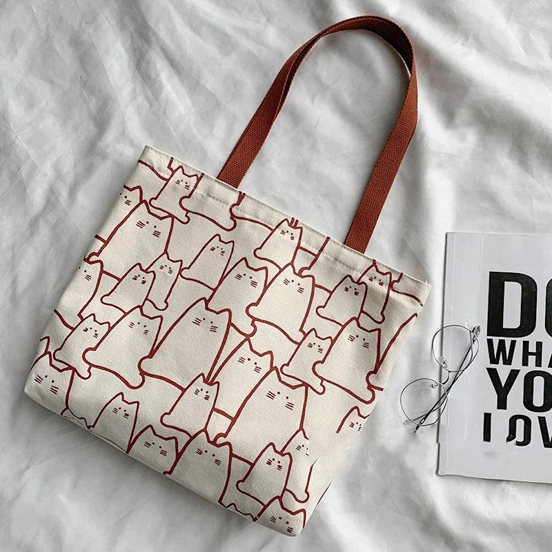 Beige cat-print canvas tote bag - interior view showing zip closure