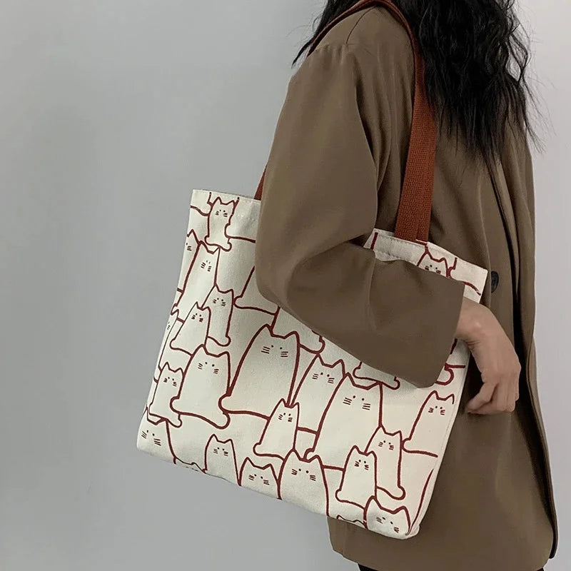 Beige cat-print canvas tote bag - side angle showing compact silhouette