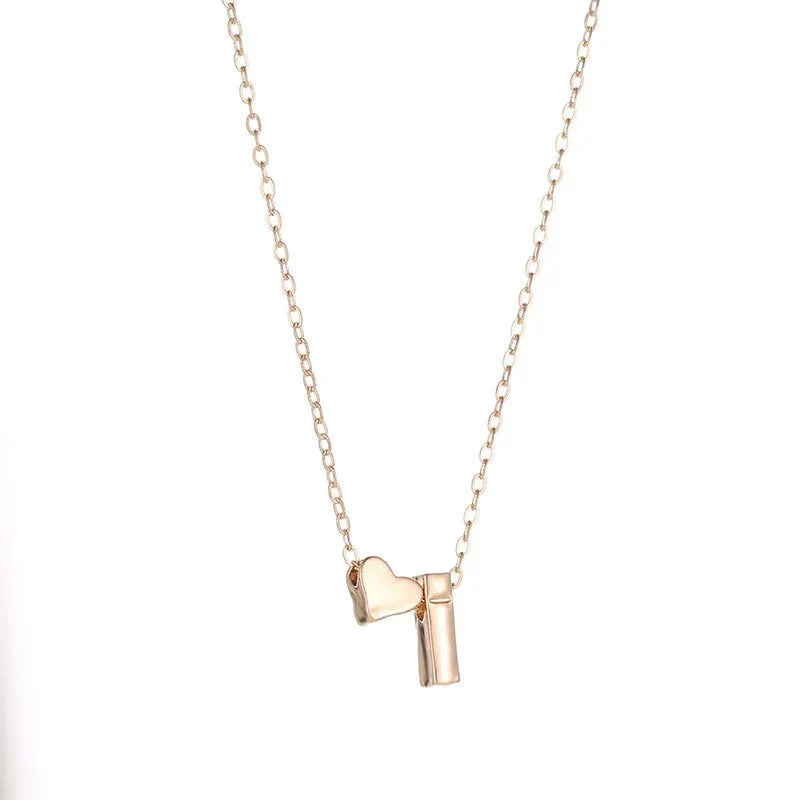 Dainty heart and initial pendant necklace in gold-tone alloy - close-up detail of heart charm - Varex HQ