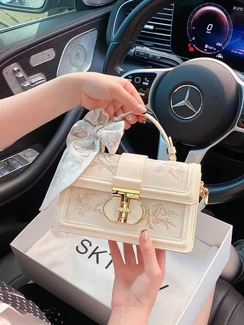 Beige vegan leather shoulder bag - close-up of gold-tone hardware and top handle