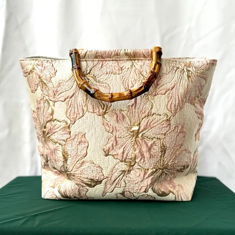 Pink embroidered canvas tote bag - lifestyle shot carried by hand
