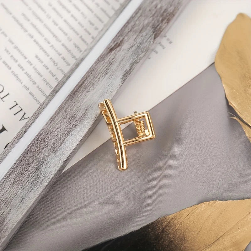 Geometric Hollow Hair Claw Clip in gold-tone metal finish, styling angle - Varex HQ