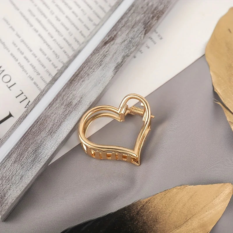 Geometric Hollow Hair Claw Clip in gold-tone metal finish, in hand for scale - Varex HQ