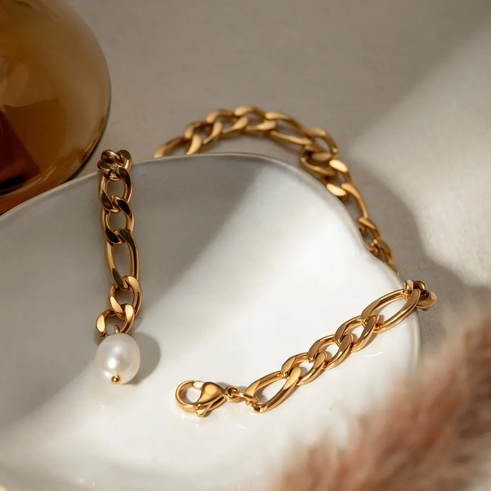 Gold-plated stainless steel pearl anklet under soft dramatic lighting