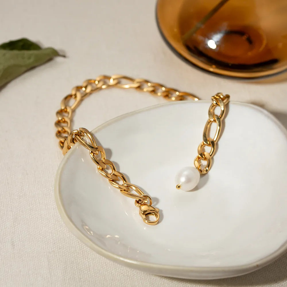 Close up view of synthetic pearl pendant on gold-plated chain anklet