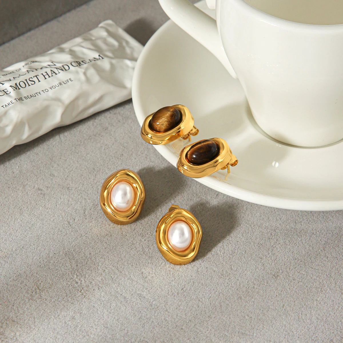 Gold-plated stud earrings with stone and faux-pearl accent, styling angle 1 - Varex HQ