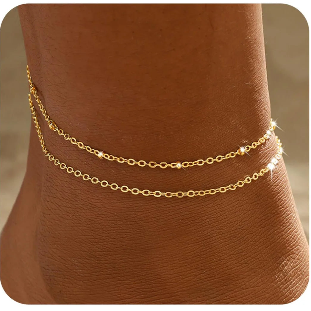 Gold-plated layered anklet and bracelet set, beach lifestyle shot, Varex HQ