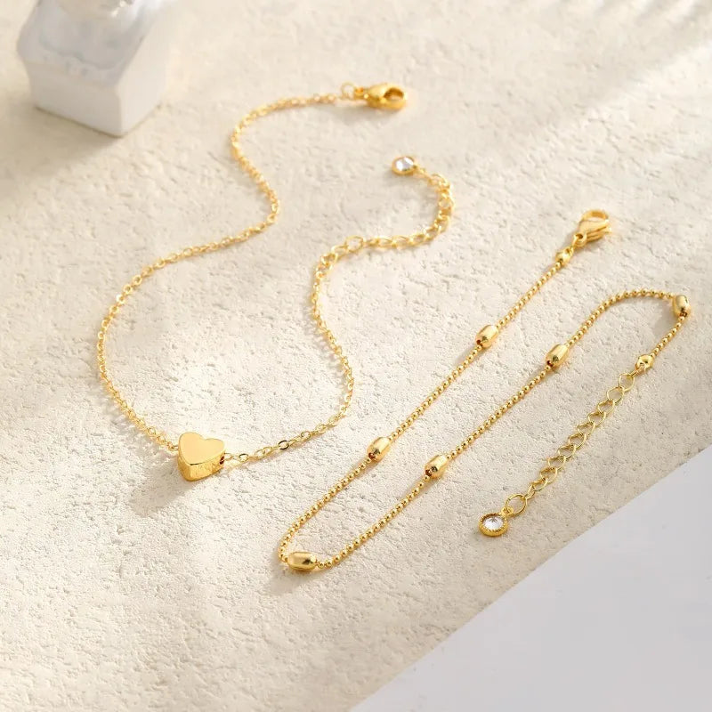 Gold-plated layered anklet and bracelet set, flat lay product shot, Varex HQ