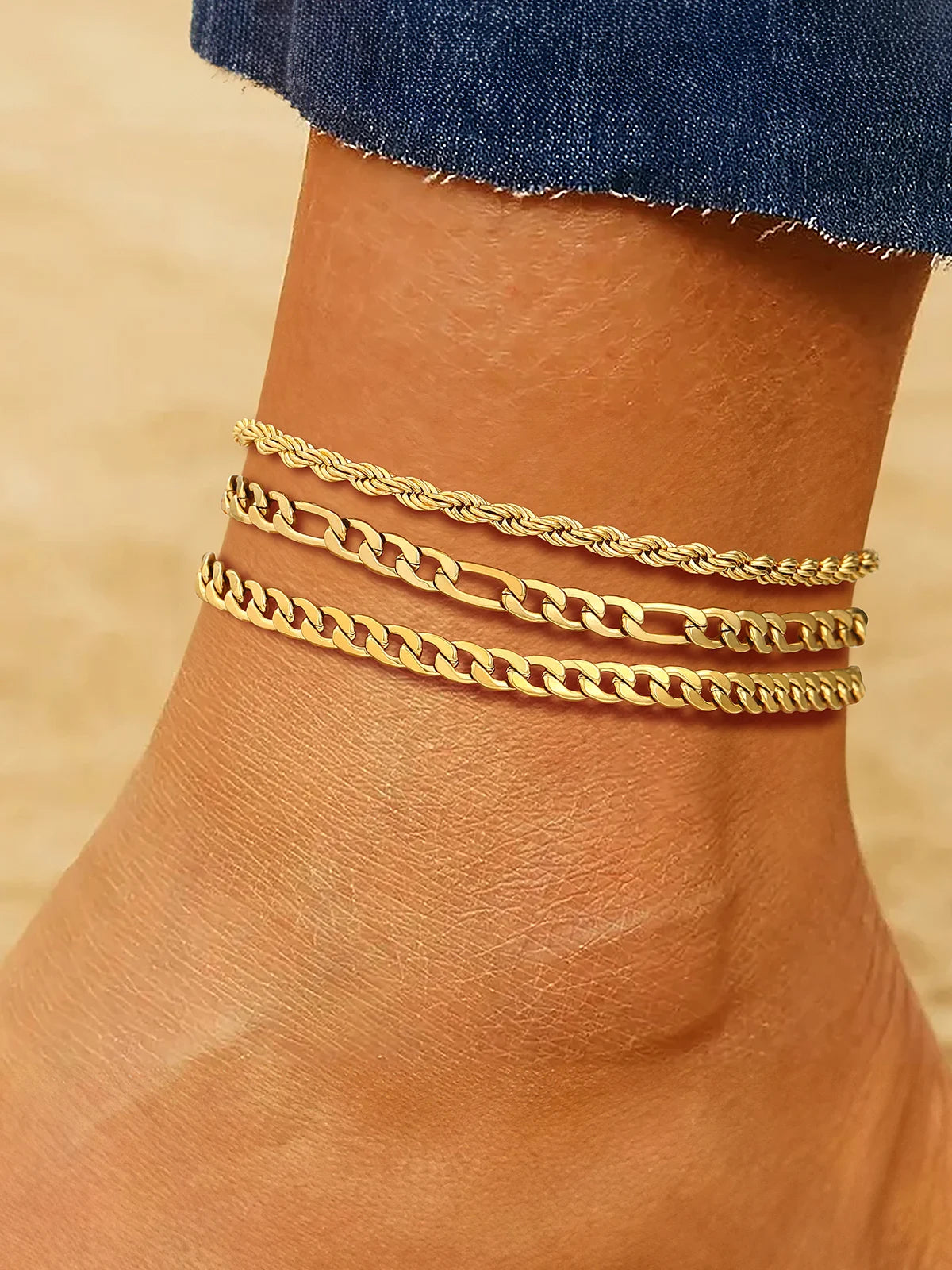 Layered chain anklet set gold-tone on model's ankle at the beach
