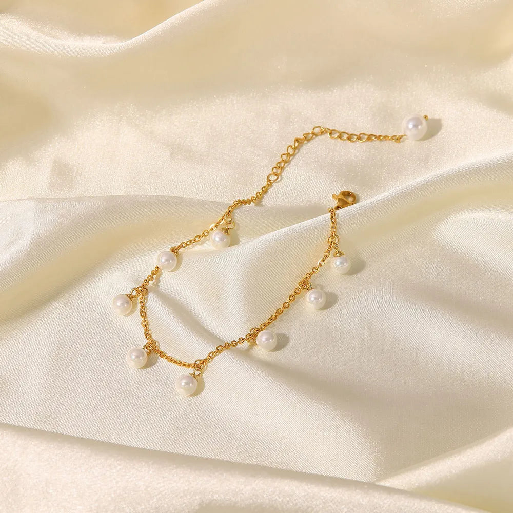 Lumina gold plated pearl charm anklet elegantly arranged on luxurious off-white satin fabric - gift inspiration from Varex HQ