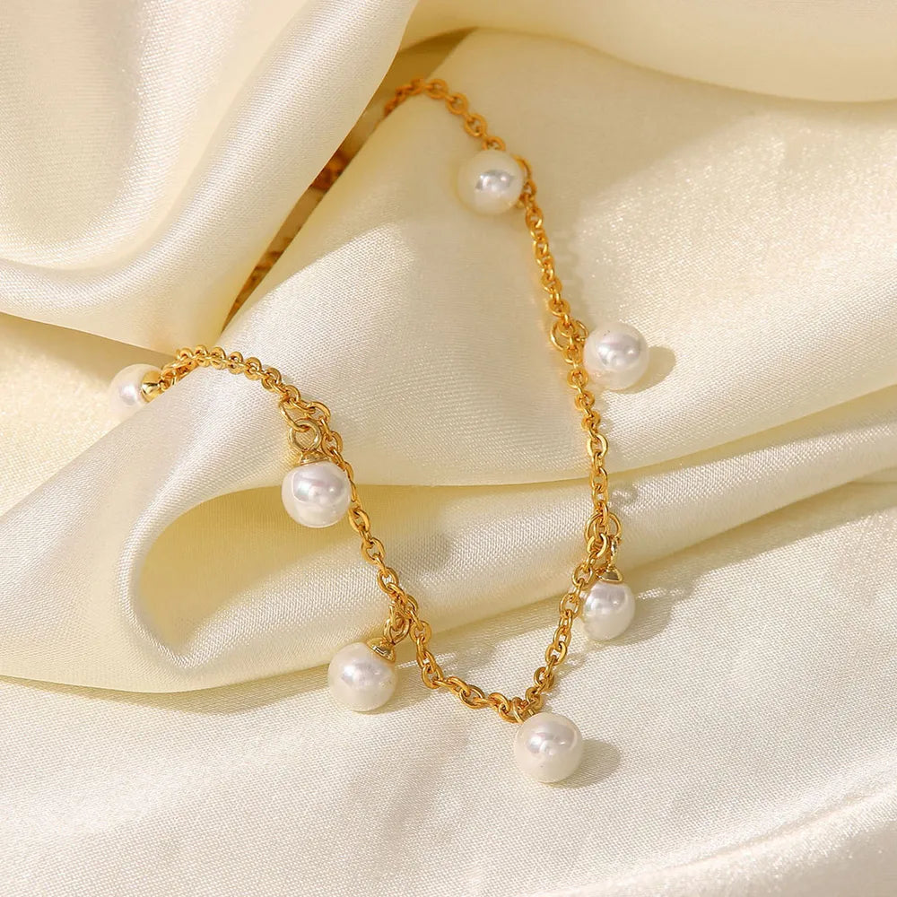 Detailed close-up view of the Lumina gold-plated pearl anklet showcasing the chain and pearls on a lustrous satin fabric backdrop - Varex HQ