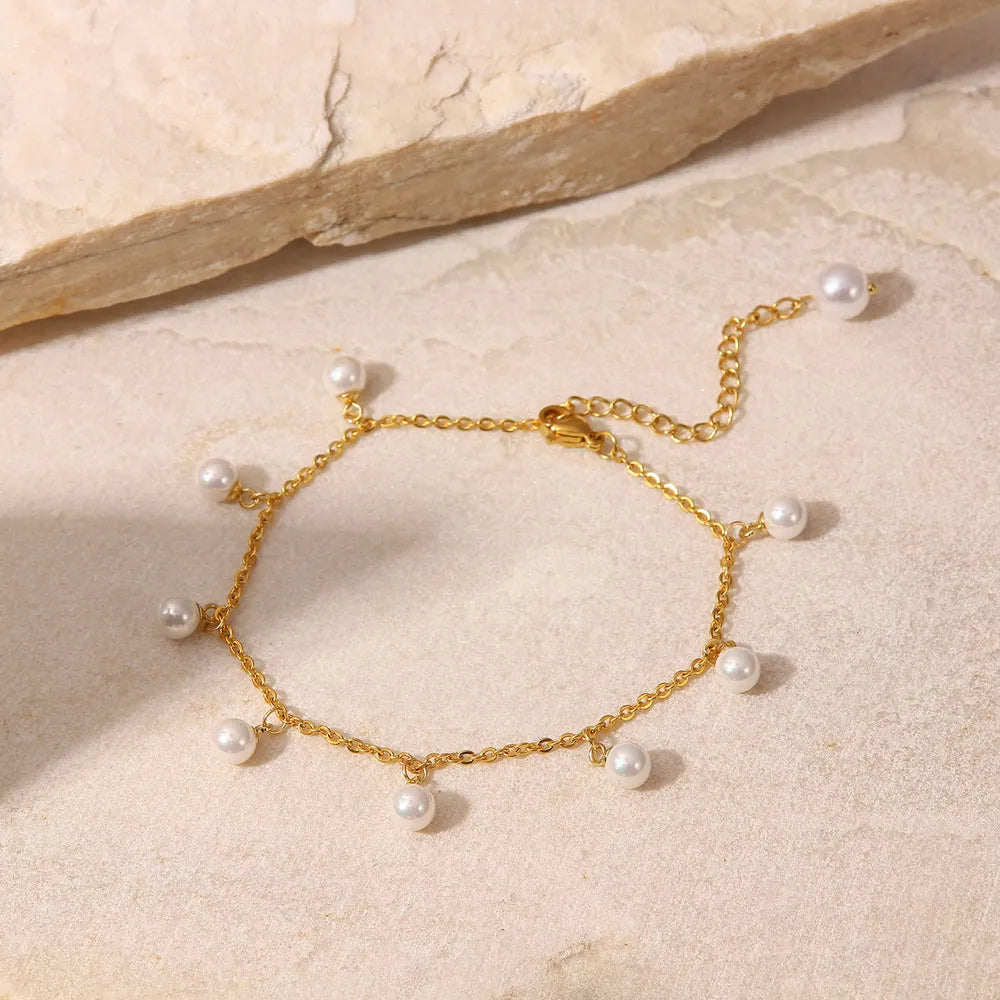 Lumina gold-plated stainless steel pearl charm anklet displayed on textured stone - Varex HQ luxury jewelry