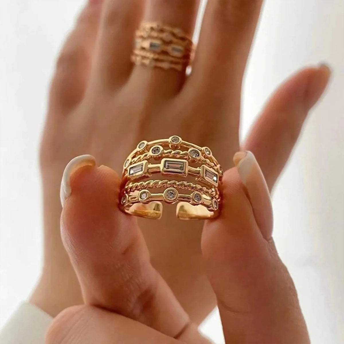 Front view of multi-layer gold-tone crystal ring with adjustable open back