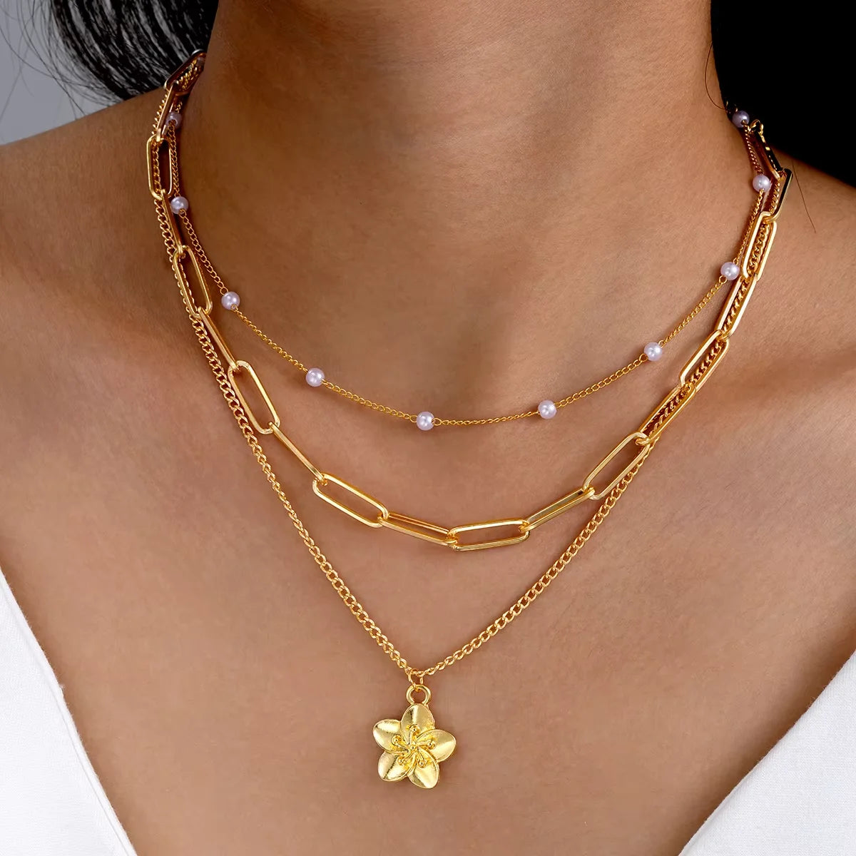 4-piece ocean charm layered necklace set in gold tones with shell, starfish, and pearl charms - texture close-up - Varex HQ