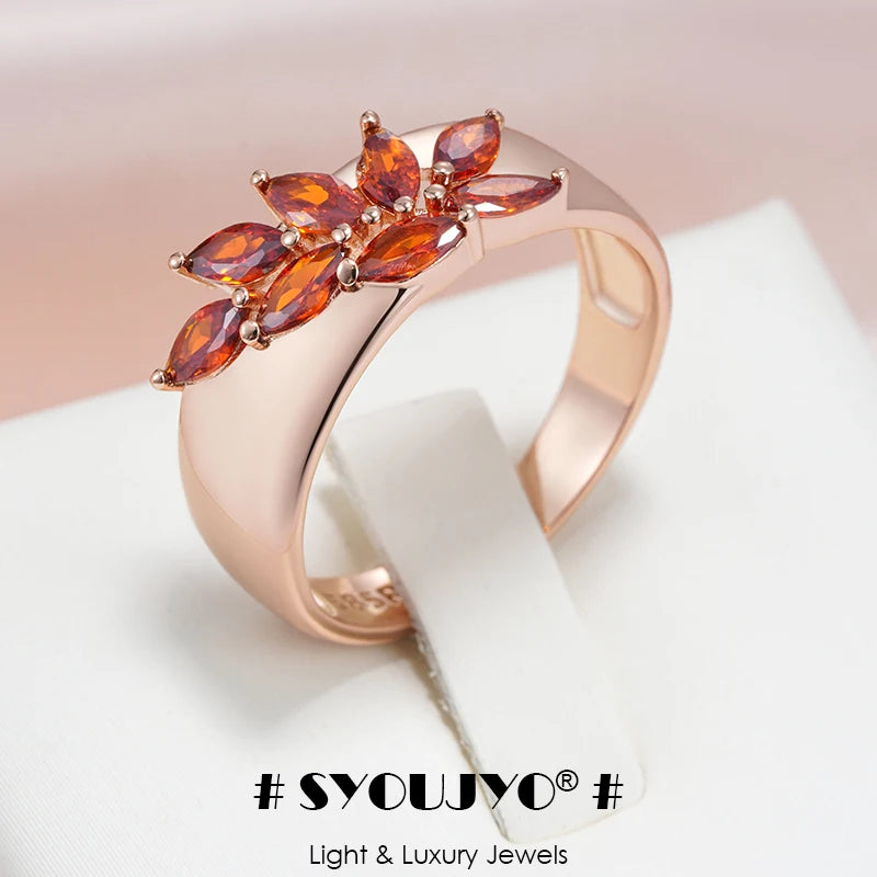 Close-up of red zircon stone set in rose gold leaf ring