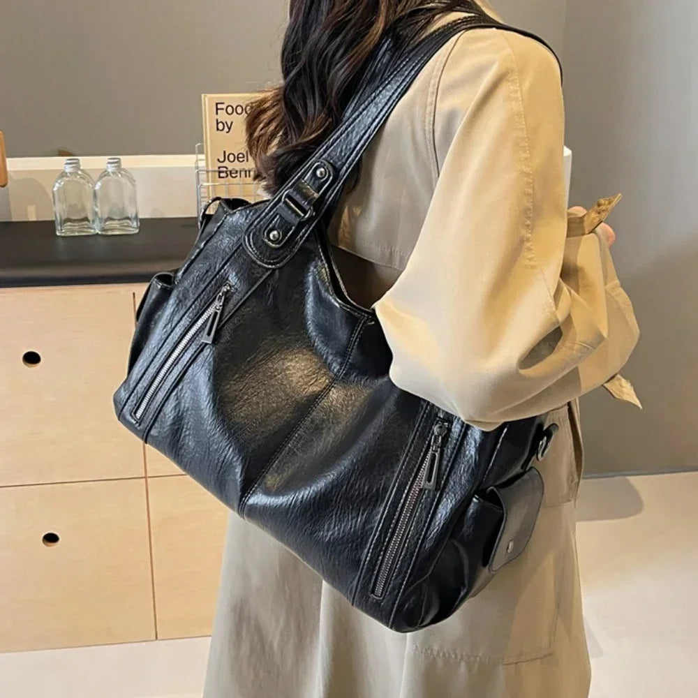 Vertical-Zip Vegan Leather Multi-Compartment Tote in black, worn on shoulder showing structured silhouette and buckle strap detail – Varex HQ