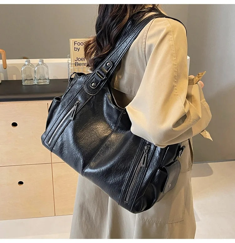 Vertical-Zip Vegan Leather Multi-Compartment Tote in black, worn over shoulder showing front zip pocket detail – Varex HQ