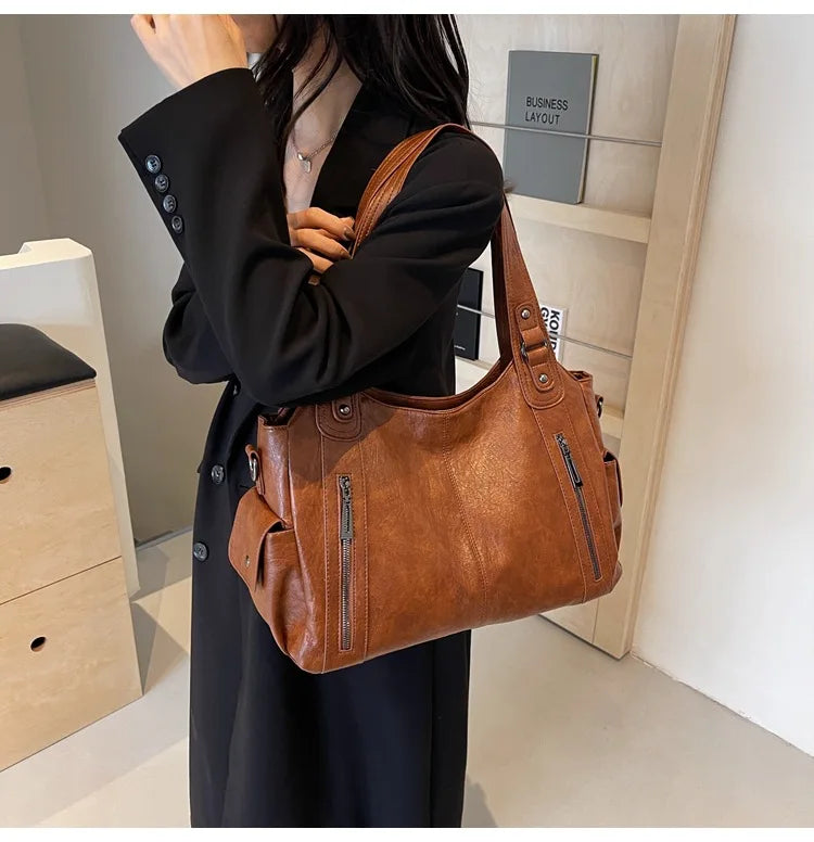 Vertical-Zip Vegan Leather Multi-Compartment Tote in brown, worn over shoulder showing buckle strap and structured silhouette – Varex HQ
